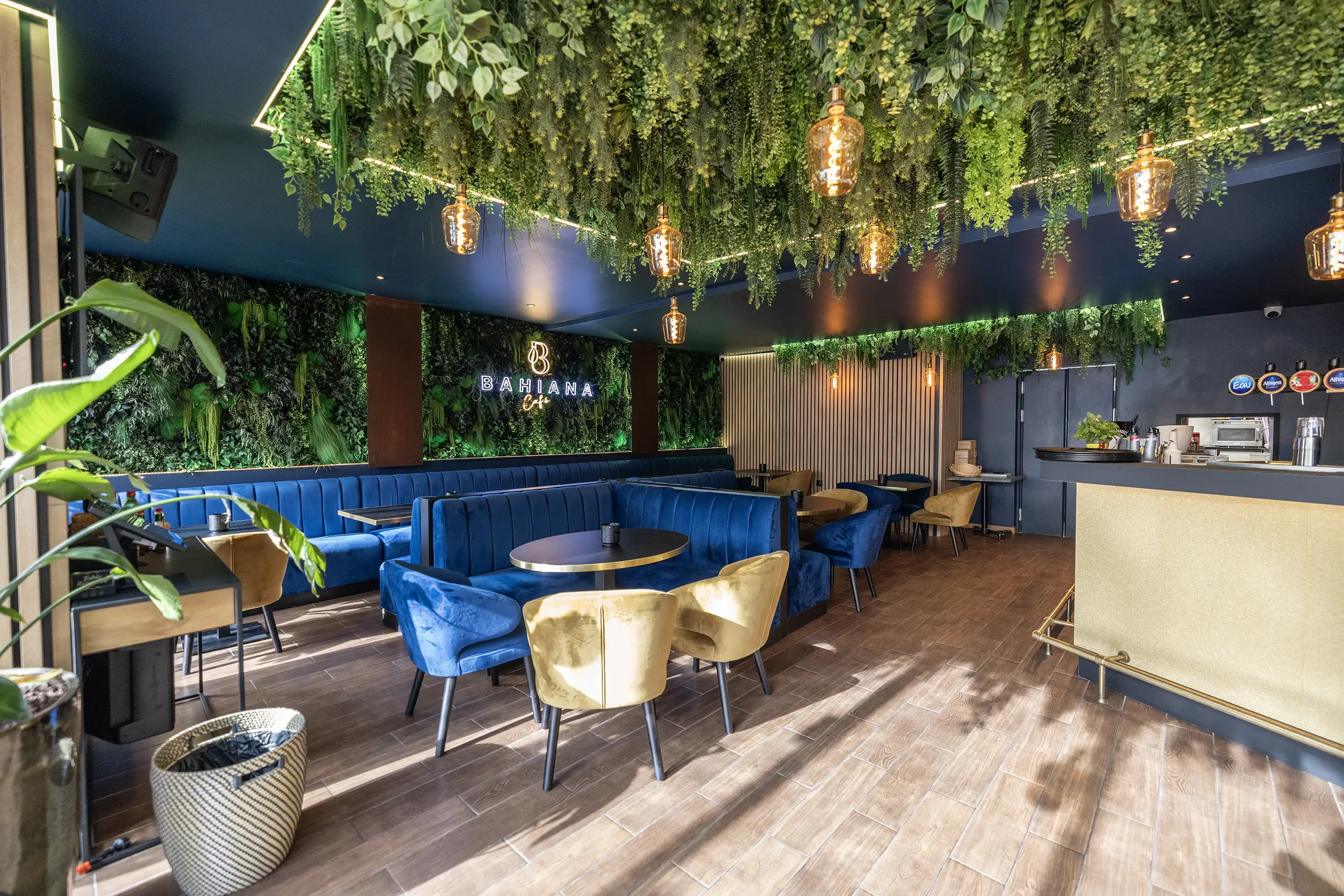 Murs végétaux et tables du Bahiana Café. C'est un bar restaurant à Paris aménagé en son et lumière par le Groupe Silam.